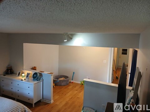 A bedroom with a white dresser and a grey desk.