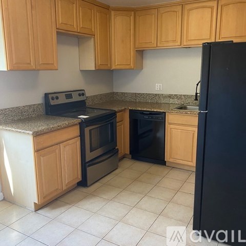 A kitchen with wooden cabinets and black appliances.