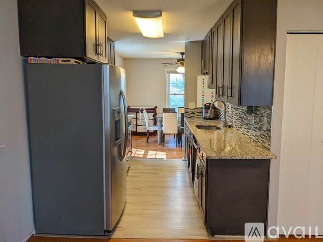 A kitchen with a refrigerator on the left and a counter on the right.