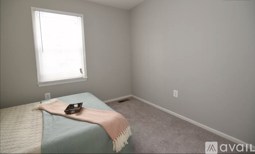 A bedroom with a bed covered in a blue and white comforter and a brown object on top of it.