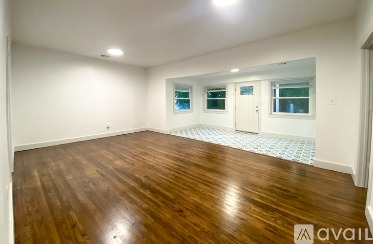 A room with wooden flooring and white walls.