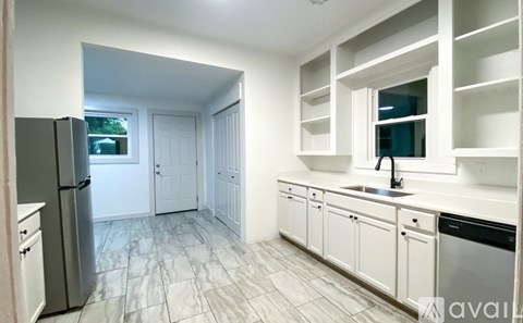 A kitchen with white cabinets and a black dishwasher.