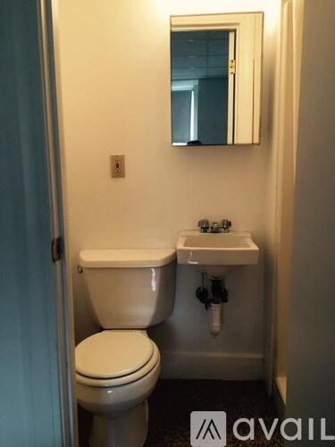 A white toilet and sink in a small bathroom.