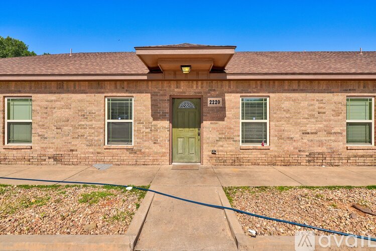 A brick house with a green door and windows.
