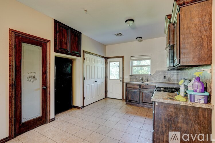 A kitchen with wooden cabinets and a tiled floor.
