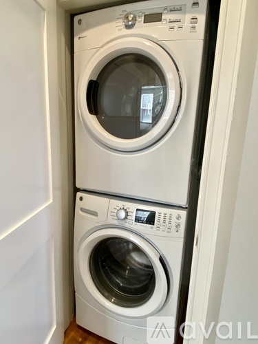 Two front loading washing machines in a small space.