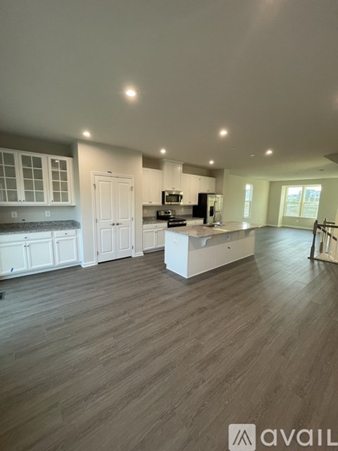 A spacious kitchen with white cabinets and a central island.