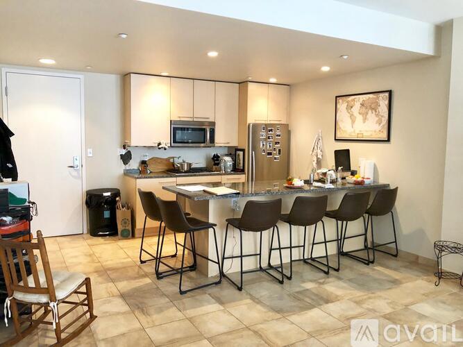 A kitchen with a table and chairs in front of a refrigerator and microwave.