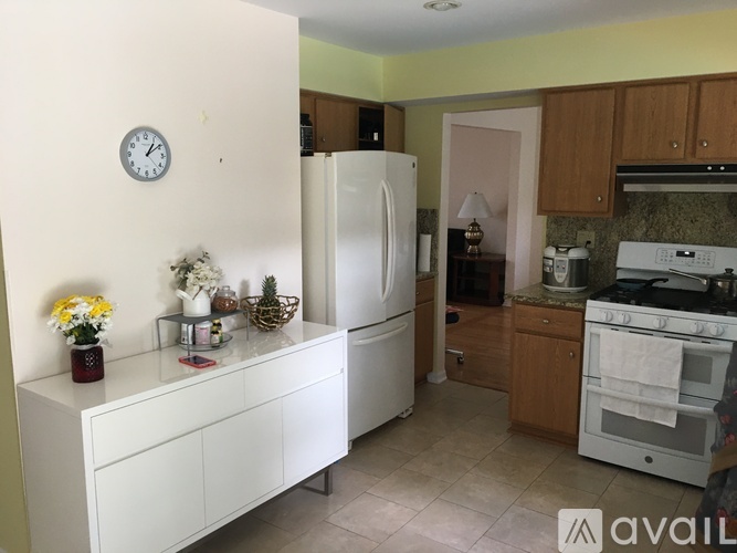 A kitchen with a white refrigerator and a white countertop.