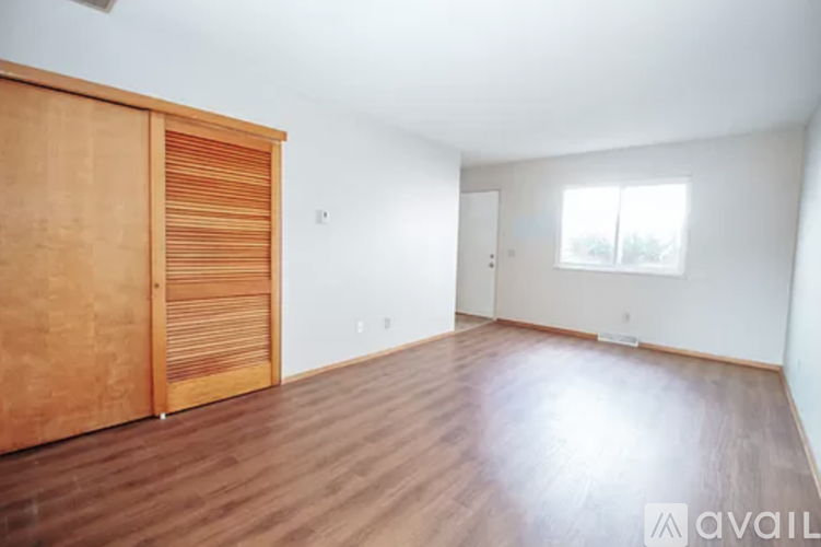 A room with wooden floors and a wooden door with a window.