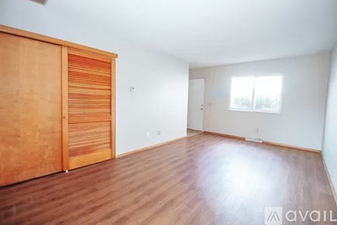 A room with wooden floors and a wooden door with a window.