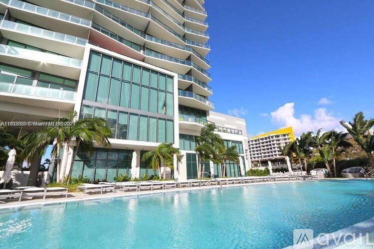 A tall building with a pool in front of it.