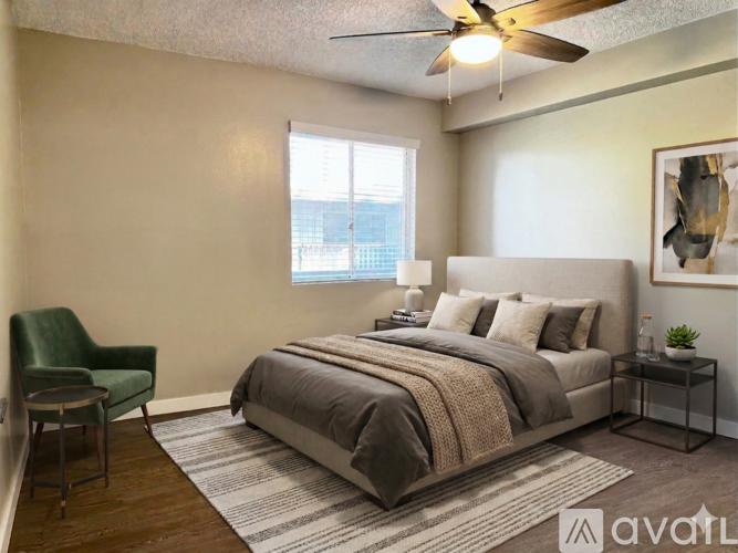 A bedroom with a bed, chair, and window.
