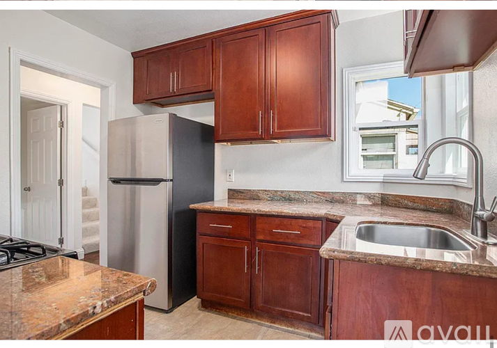 A kitchen with brown cabinets and a granite countertop.