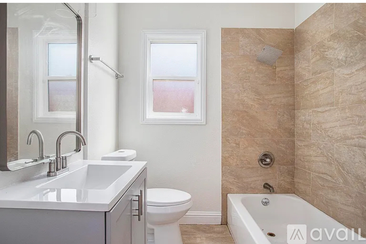 A bathroom with a tub, toilet, and sink.