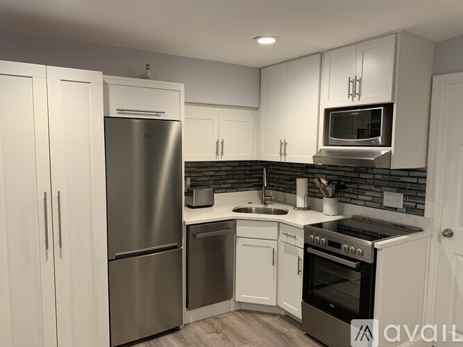 A kitchen with a refrigerator, oven, and microwave.