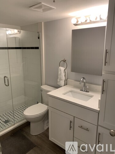 A bathroom with a toilet, sink, and mirror.