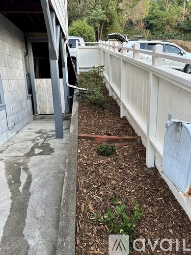 A white fence runs along the side of a building.