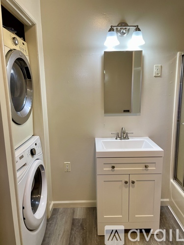 A small bathroom with a washer and dryer built into the wall.