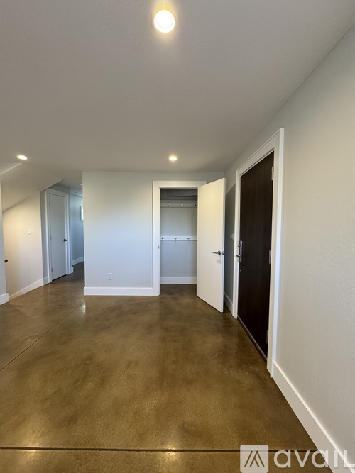 A long hallway with doors on both sides and a brown floor.