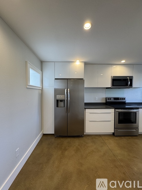 A kitchen with white cabinets and a stainless steel refrigerator.