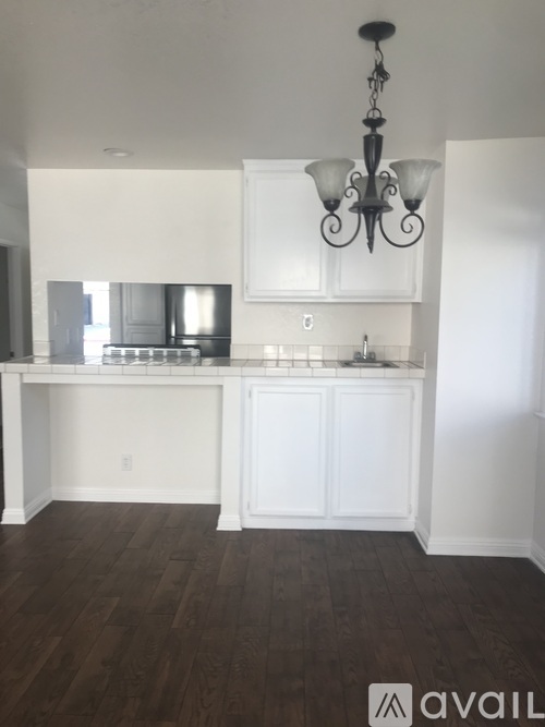 A kitchen with white cabinets and a chandelier.