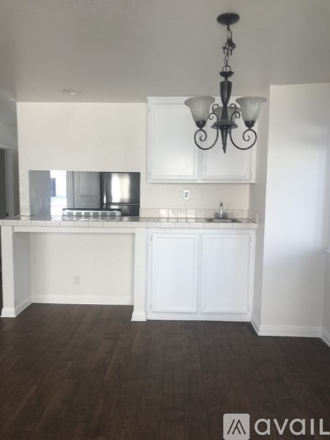 A kitchen with white cabinets and a chandelier.