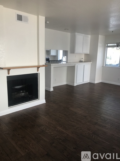 A living room with a fireplace and wooden floors.