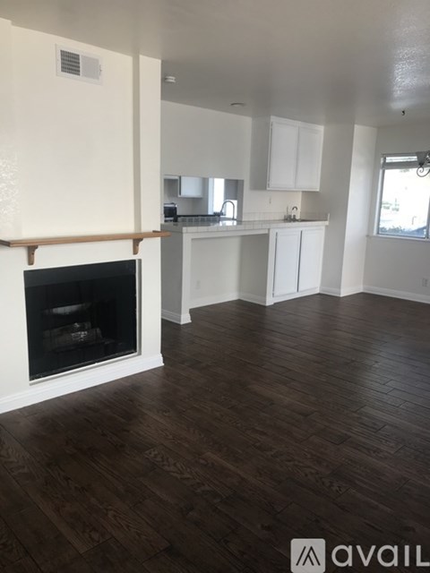 A living room with a fireplace and wooden floors.