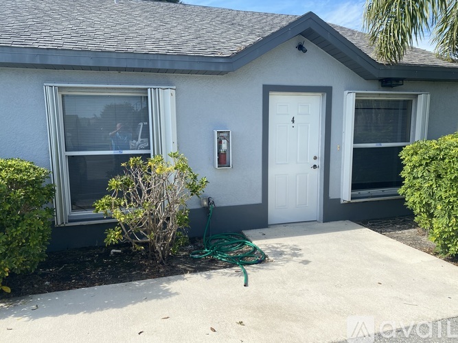 A grey house with a white door and windows.