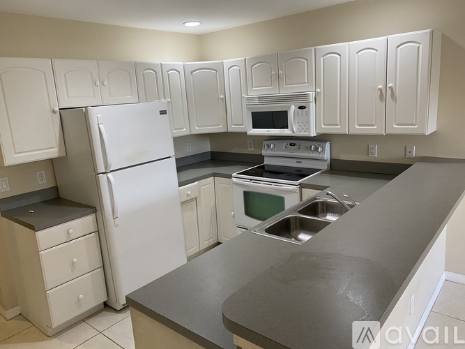 A kitchen with white appliances and cabinets.