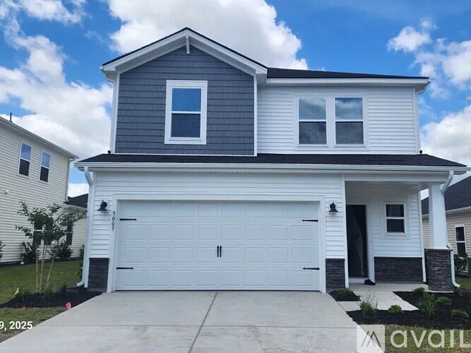 A two-story house with a garage is available for purchase.