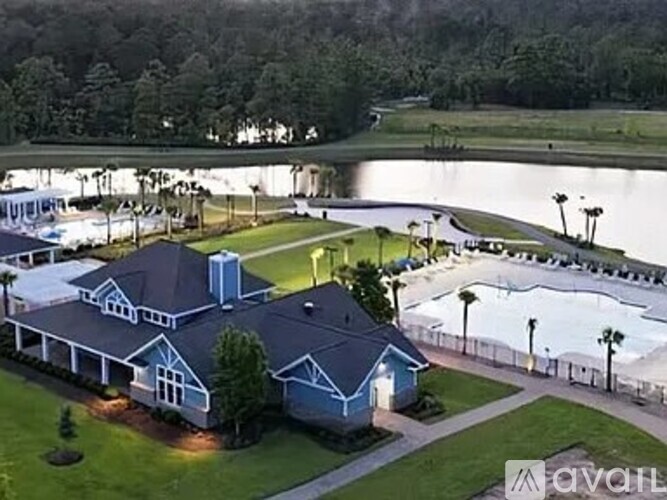 A house with a blue roof and a pool in front of it.