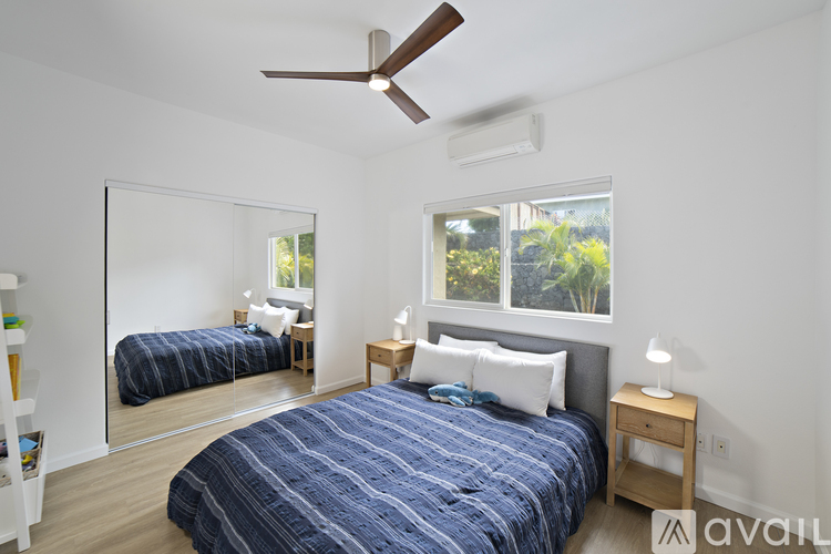 A bedroom with a large bed and a ceiling fan.