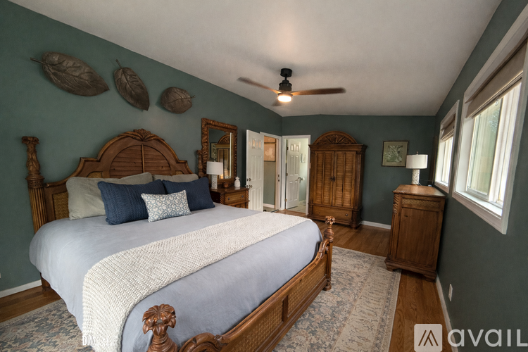 A bedroom with a large bed and wooden furniture.