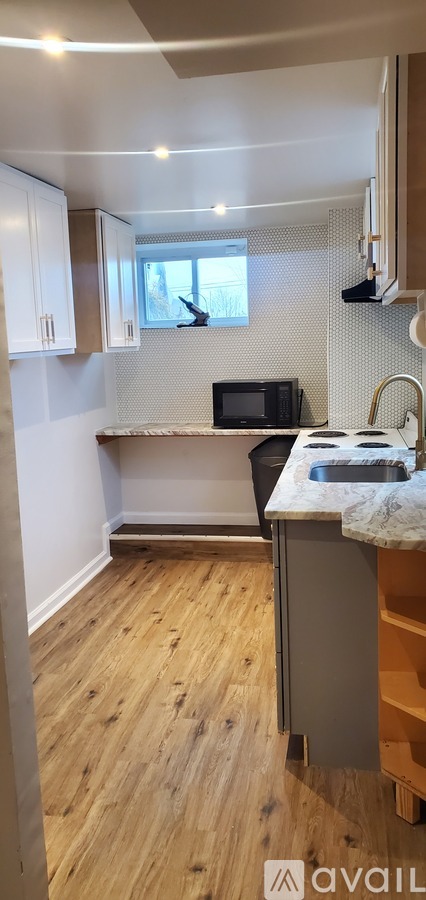 A kitchen with wooden floors and white walls.