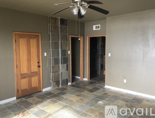 A room with a ceiling fan and tile flooring.