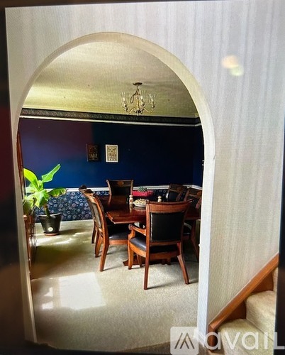 A dining room with a wooden table and chairs.