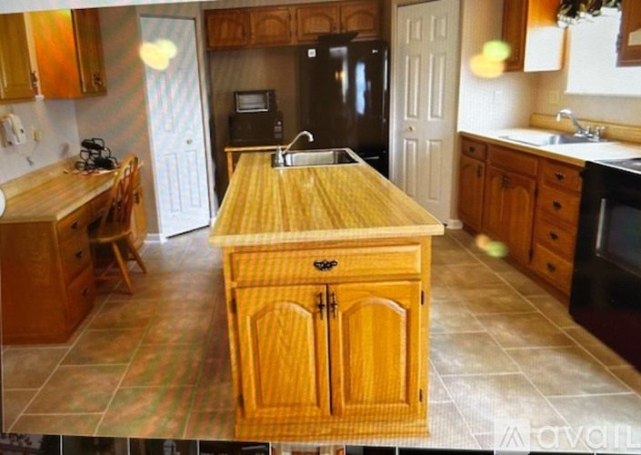 A kitchen with wooden cabinets and a wooden island.