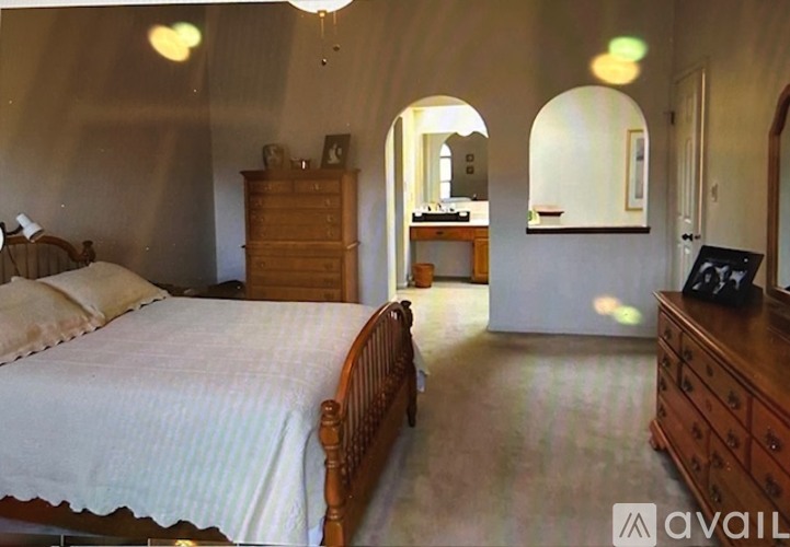 A bedroom with a bed, dresser, and mirror.