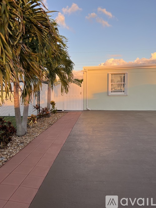A house with a white fence and a tree in front of it.