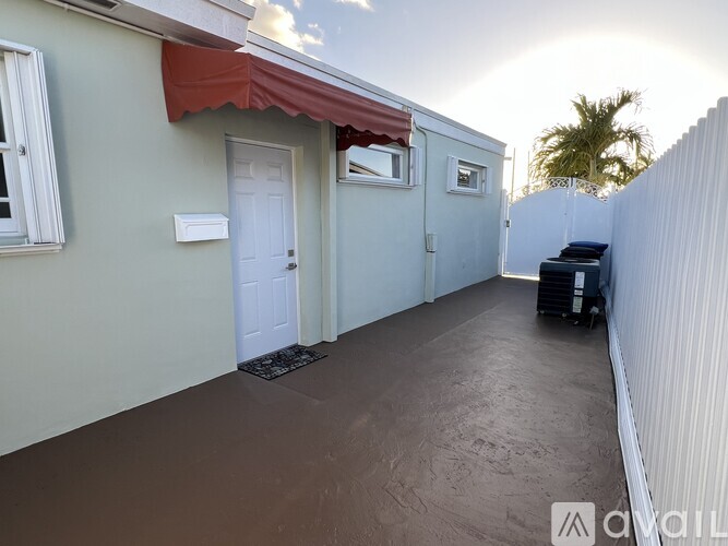 A patio area with a white door and a red awning.