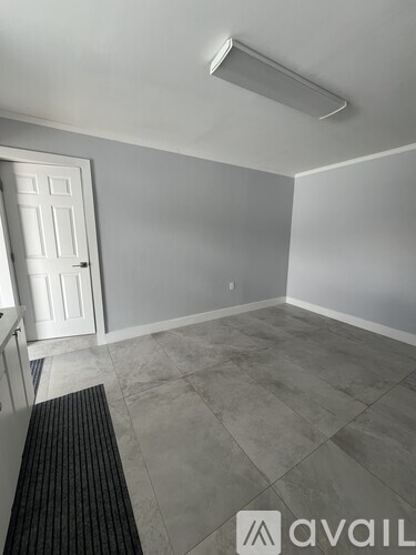 A room with a door and a mat on the floor.