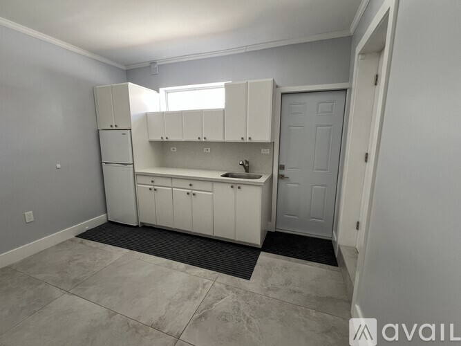 A kitchen with white cabinets and a sink.