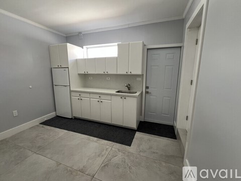 A kitchen with white cabinets and a sink.