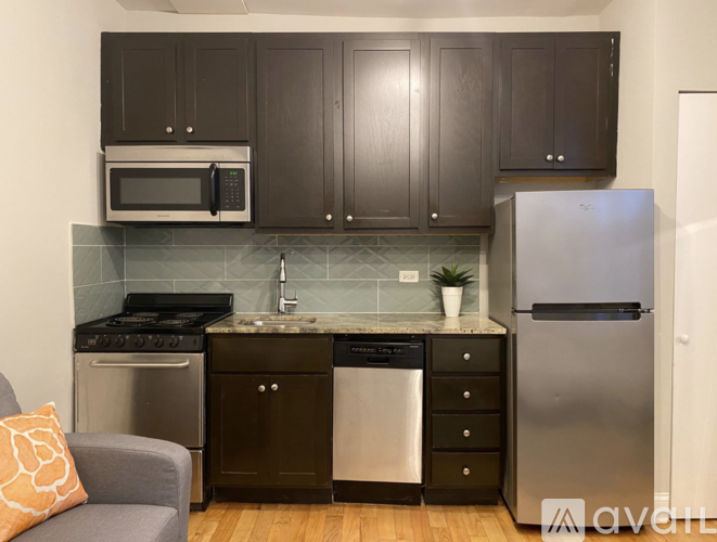 A kitchen with dark brown cabinets and stainless steel appliances.