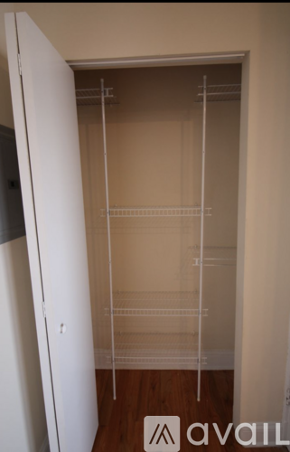 A walk in closet with shelves and a door.