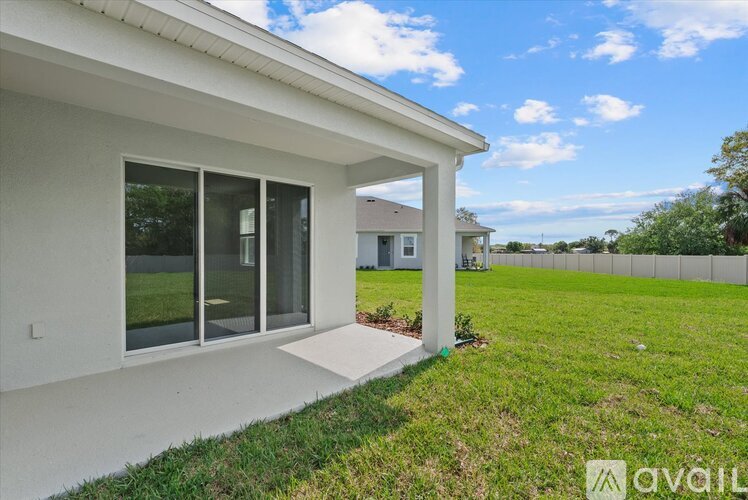 A modern house with a white exterior and a large glass window.