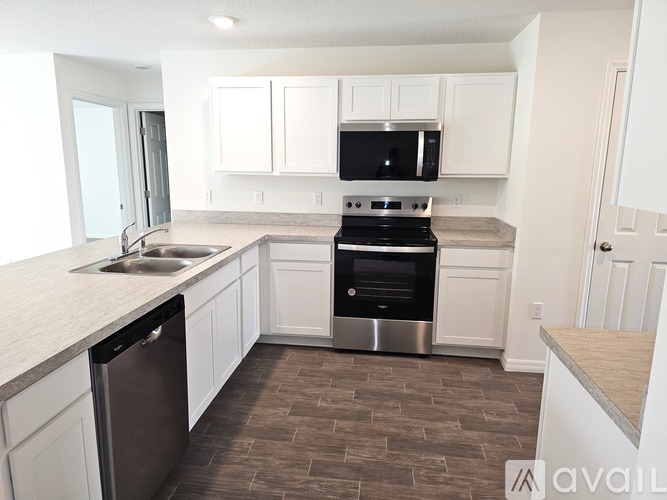 A kitchen with white cabinets and a black stove top oven.