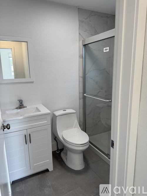 A white toilet sits next to a sink in a bathroom.
